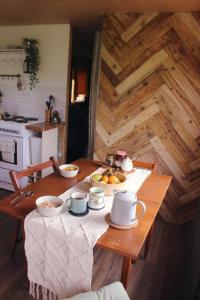 a wooden table with cups and bowls of food on it at The Cabin Project in Portglenone