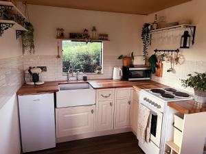 a kitchen with white appliances and a window at The Cabin Project in Portglenone