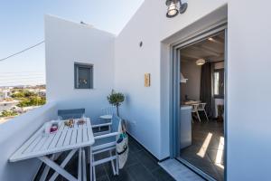 a room with a balcony with a table and chairs at Zeus Suite in Triovasálos