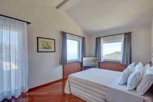 a bedroom with a bed and two windows at Il Leccio - Luxury Resort Portofino Monte in Santa Margherita Ligure +37 photos