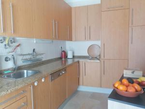 una cucina con armadi in legno e un cesto di frutta di Cabanas Riverside a Cabanas de Tavira