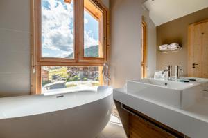 a bathroom with a tub, sink, and bathtub at Le Chalet Blanc Hôtel & Spa in Montgenèvre