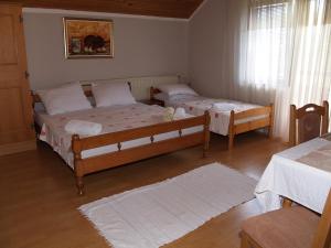 two beds in a room with two tables at Jelena in Korenica