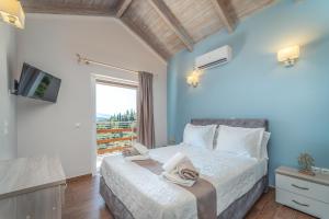 a bedroom with a bed and a tv and a window at Koumaries Villas in Lygia