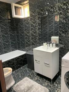 a bathroom with a white sink and a toilet at Magic Vendégház in Abádszalók