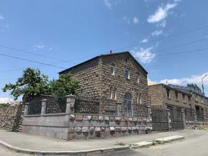 a brick building with a fence in front of it at MITANE in Sisian