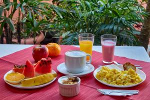 a table with a breakfast of fruit and coffee and juice at Oscar Hotel in Florianópolis