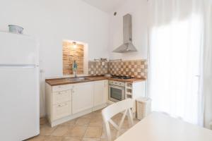 a white kitchen with a sink and a stove at Puntuso Vacanze in Matino