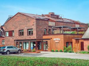 a brick building with a car parked in front of it at Staffanstorps Gästis Hotell in Staffanstorp