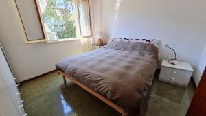 Luogo di Pace في غرادو: سرير صغير في غرفة مع نافذة