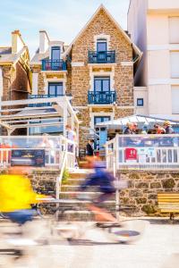 a group of people riding motorcycles in front of a building at Hôtel Les Charmettes - Saint Malo in Saint Malo