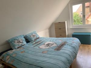 1 dormitorio con 1 cama con edredón azul en Vacanzamare, en Wenduine