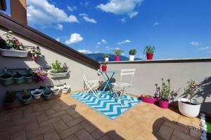a patio with chairs and potted plants on a building at SUITE Assisi - L attico delle meraviglie in Santa Maria degli Angeli