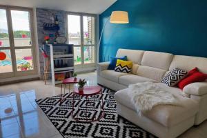 a living room with a white couch and a blue wall at SUITE Assisi - L attico delle meraviglie in Santa Maria degli Angeli