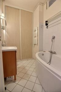 een witte badkamer met een bad en een wastafel bij 207535 - Appartement 4 personnes Champ de Mars in Parijs