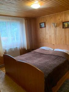1 dormitorio con 1 cama grande en una habitación con ventana en Cottage u Romana, en Yaremche