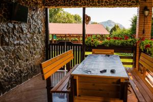 a wooden table and benches on a patio at Vila Izvoarele in Izvoarele