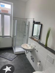 a bathroom with a sink and a shower at Haus Alf in Wilhelmshaven