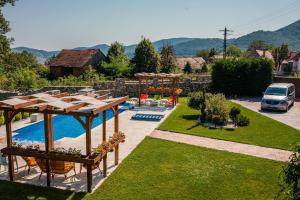 a backyard with a pool and a table and chairs at Vila Izvoarele in Izvoarele