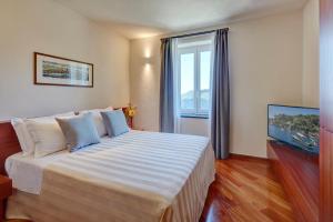 a hotel room with a large bed and a window at Il Leccio - Luxury Resort Portofino Monte in Santa Margherita Ligure
