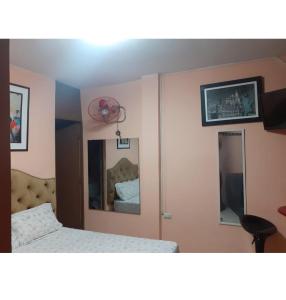 1 dormitorio con 1 cama y 2 espejos en Hospedaje Las Palmeras, en Piura