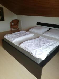 2 camas individuales en una habitación con silla en Ferienwohnung / Monteurswohnung in ruhiger Waldlage en Borghees