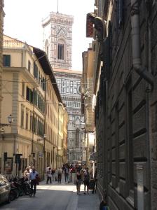 eine Gruppe von Menschen, die eine Straße mit einer Kathedrale entlang gehen in der Unterkunft Il Giglio in Florenz