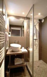 a bathroom with a sink and a shower at The Originals Boutique, Hôtel Marytel, Montbrison (Inter-Hotel) in Montbrison