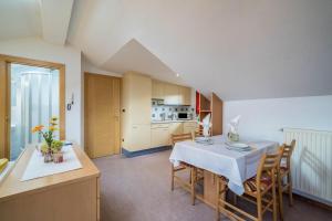 a kitchen and dining room with a table and chairs at Ferienwohnung Bozen in Meltina
