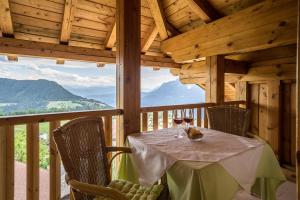 a table with a glass of wine sitting on a porch at Ferienwohnung Bozen in Meltina