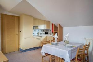 a kitchen and dining room with a table and chairs at Ferienwohnung Bozen in Meltina +12 photos
