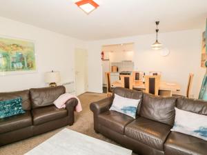 a living room with two leather couches and a kitchen at Brunston Castle in Girvan