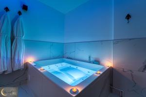 uma banheira com luz azul na casa de banho em Spa et Sauna au coeur de Metz (unenuitametz) em Metz