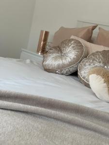 two wrapped up pillows on top of a bed at Stanton Cross 5 persons 3 Bed Home in Wellingborough
