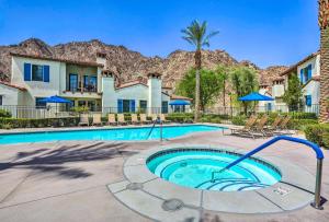 Una piscina con sillas y un resort. en Desert Views and Pool Access Home in La Quinta!, en La Quinta