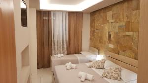 フォッローニカにあるAffittacamere Casa Brajanの石壁の客室で、ベッド2台が備わります。