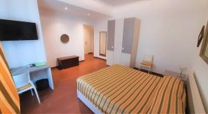 a bedroom with a bed and a desk and a television at B&B Five in Rome