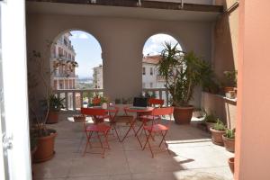 een patio met een tafel en stoelen op een balkon bij Appartamento Camillo in Macerata