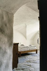 una camera con un letto in una stanza vuota di Hotel Weiss Kreuz a Splügen