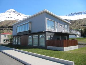 una grande casa con montagne sullo sfondo di Seydisfjördur Apartment a Seyðisfjörður