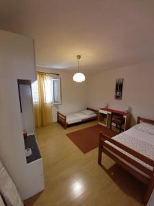 a living room with two beds and a table at Apartman Sara in Preko