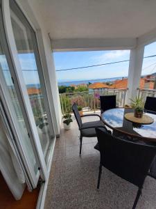 eine Terrasse mit einem Tisch und Stühlen auf dem Balkon in der Unterkunft Apartman Sara in Preko