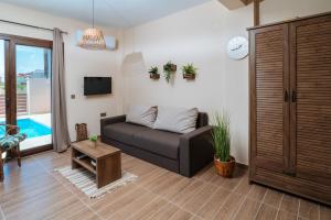 a living room with a couch and a tv at SALVE holiday houses in Paralia Katerinis