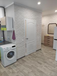 a kitchen with a washing machine in a room at New apartments Уютная студия в центре города Дзержинка in Kryvyi Rih