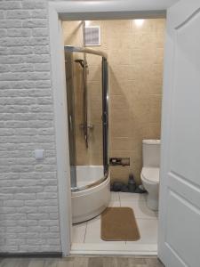 a bathroom with a shower and a tub and a toilet at New apartments Уютная студия в центре города Дзержинка in Kryvyi Rih