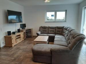 ein Wohnzimmer mit Couch und Fernseher in der Unterkunft Ferienhaus 1 - 55483 Unzenberg in Göbenhausen