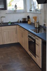 a kitchen with wooden cabinets and a blue counter top at Ferienhaus 1 in Unzenberg