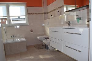ein weißes Badezimmer mit Toilette und Waschbecken in der Unterkunft Ferienhaus 1 - 55483 Unzenberg in Göbenhausen