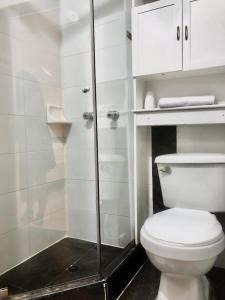 a bathroom with a toilet and a glass shower at Hotel Sweet Home in Bogotá
