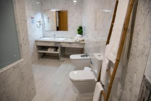 a bathroom with a toilet and a sink at Hotel Marisol in Macedo de Cavaleiros